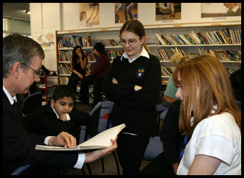 Teacher showing a book to a small group of pupils