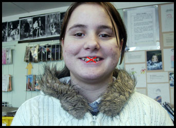 Teenage girl with cross over her mouth symbolising no voice